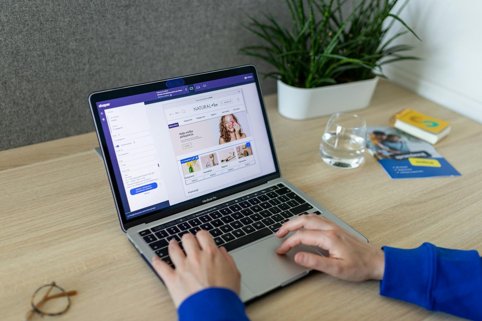 A person navigating an online store on a laptop, at a modern indoor office desk.